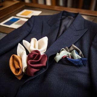 Folded pocket squares arranged beside a navy suit jacket